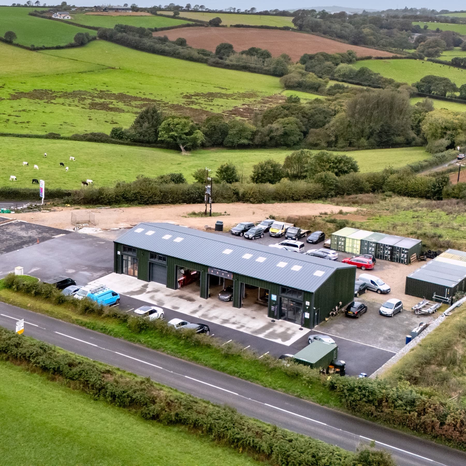 Aerial view of Totnes Cross Garage beside the A381 at Halwell, with fields and grazing cattle behind